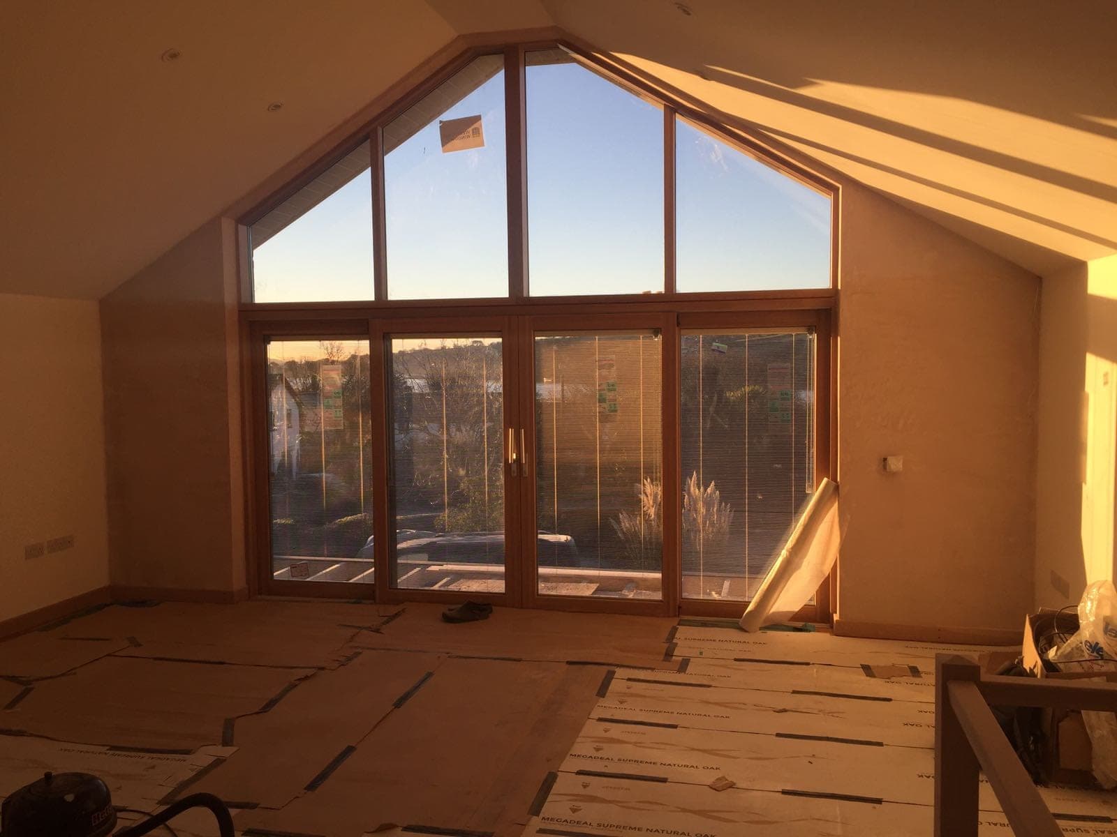 Glazed gable and garden doors bringing daylight into a room during finishing